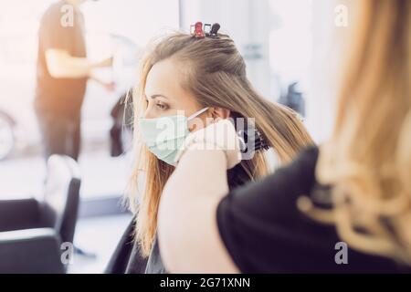 Frau, die den Friseur besucht und ein neues Styling trägt Gesichtsmaske Stockfoto