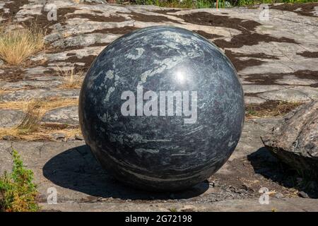 Großer Steinglobus, Teil der Pars Pro Toto Skulptur von Alicja Kwade, auf der Kunstveranstaltung der Helsinki Biennale 2021 auf der Insel Vallisaari in Helsinki, Finnland Stockfoto