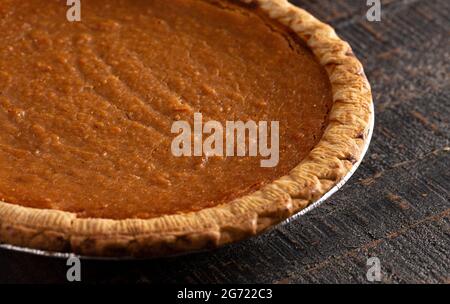 Eine ganze Süßkartoffel-Torte auf einem Tisch aus dunklem Holz Stockfoto