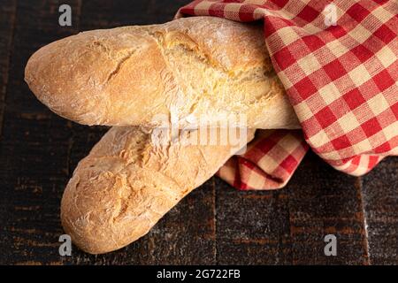 Zwei Laibe frisches französisches Baguette auf einem rustikalen Holztisch Stockfoto