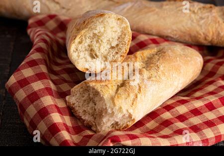 Zwei Laibe frisches französisches Baguette auf einem rustikalen Holztisch Stockfoto