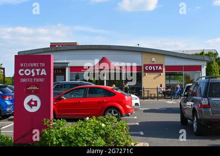 Andover, England - Juni 2021: Menschen und Autos vor einer Drive-Thru-Filiale von Costa Coffee Stockfoto