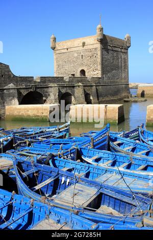 Fischerboote im Hafen von Essaouira vor der Kulisse der Zitadelle, Marokko Stockfoto