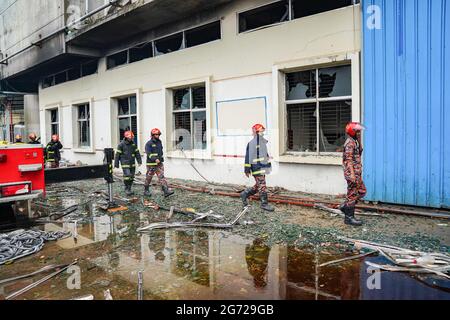 Narayanganj, Bangladesch. Juli 2021. Feuerwehrleute vor der verbrannten Hashem Foods Limited-Fabrik in Rupganj, Bezirk Narayanganj, am Stadtrand von Dhaka, gesehen.EIN massiver Brand in einer Lebensmittelfabrik in Bangladesch hat mindestens 52 Menschen getötet, die von Flammen gefangen waren und viele Arbeiter gezwungen haben, aus den oberen Stockwerken um ihr Leben zu springen. Unter Berufung auf Polizeibeamte. Kredit: SOPA Images Limited/Alamy Live Nachrichten Stockfoto