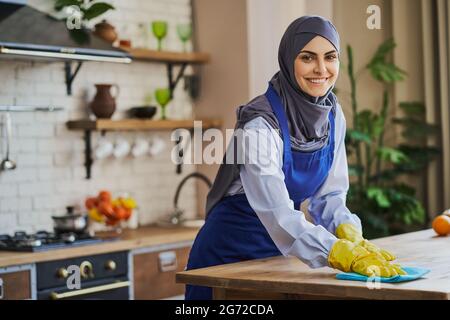 Eine arabische Frau putzt einen Tisch in der Küche Stockfoto