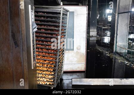 Narayanganj, Bangladesch. Juli 2021. Blick auf Tabletts mit Brot und nassem Boden nach einem Feuer, das am Donnerstagabend in der Fabrik von Hashem Foods Ltd in Rupganj, Bezirk Narayanganj, am Stadtrand von Dhaka ausbrach.mindestens 52 Menschen wurden tot aufgefunden, 25 weitere Verletzte und viele werden nach einem massiven Brand in einer Fabrik in die Falle getappt, die Ursache des Feuers, der im Erdgeschoss eines mehrstöckigen Gebäudes der Fabrik ausging, ist noch nicht bekannt. Kredit: SOPA Images Limited/Alamy Live Nachrichten Stockfoto