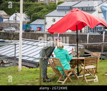 Porthleven,Cornwall,10. Juli 2021,zwei Damen küssten sich, während sie den herrlichen Sonnenschein in Porthleven, Cornwall genossen. Die Temperatur lag bei 18C, die Vorhersage ist für Gewitter morgen.Quelle: Keith Larby/Alamy Live News Stockfoto