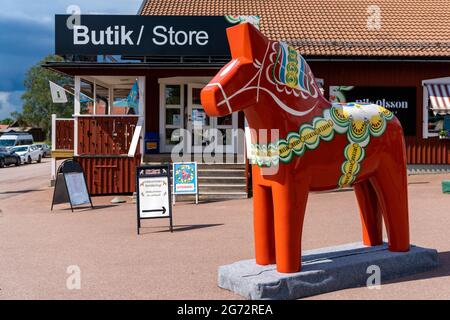 Nusnas, Schweden - 6. Juli 2021: Großes farbenfrohes schwedisches Dala-Pferd aus Holz vor einem Souvenirladen in Nordschweden Stockfoto