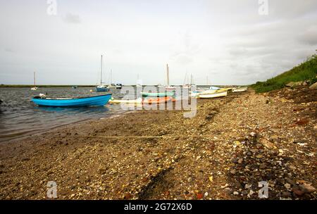 Kleine Boote, die an einem Kiesstrand festgemacht wurden Stockfoto