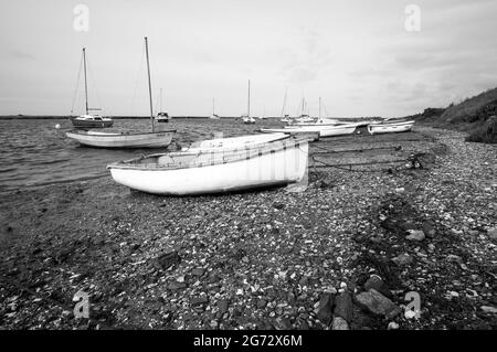 Kleine Boote, die an einem Kiesstrand festgemacht wurden Stockfoto