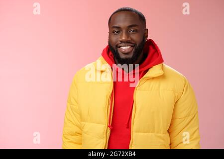 Waist-up glücklich charismatisch gut aussehenden bärtigen Kerl in gelb Jacke rot hoodie lächelnd fröhlich weiß perfekt Lächeln sprechen haben nett freundlich Stockfoto
