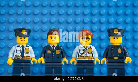 Tambow, Russische Föderation - 05. Juli 2021 vier Lego-Polizisten stehen in einer Reihe gegen die blaue Lego-Grundplatte. Stockfoto