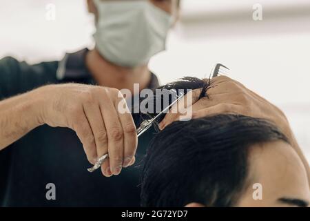 Frisur bei einem Herrenbarbershop.Frisur mit einer Schere Stockfoto