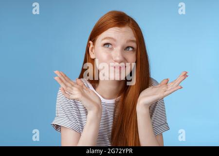 Umständlich unbequem attraktiv Rotschopf beliebtes Mädchen versuchen, denken bis Entschuldigung Gefühl widerwillig stehend zweifelhaft zuckend Hände ausbreiten Stockfoto