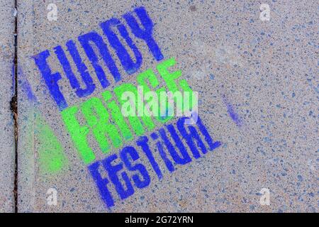 Saint John, NB, Kanada - 14. August 2017: Ein Fundy Fringe Festival-Logo in blau und grün auf einem Betonsteig gemalt. Stockfoto