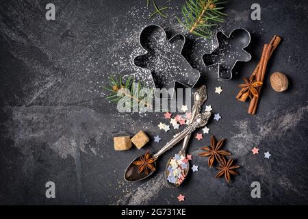 Draufsicht auf weihnachtliche Backzutaten auf schwarzem Marmorhintergrund mit Kopierfläche Stockfoto