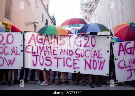 Venedig, Italien. Juli 2021. Demonstranten halten während der Demonstration ein Banner und Regenschirme in der Hand. Ein Protest gegen die G20 (Gruppe von zwanzig) fand am Meer von Venedig, in der Gegend namens Zattere statt. Während des Protestes kam es zu heftigen Zusammenstößen zwischen Polizei und Demonstranten. Kredit: SOPA Images Limited/Alamy Live Nachrichten Stockfoto