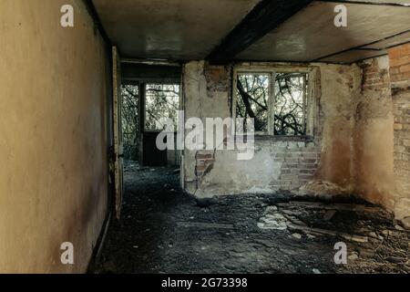 Ein verfallenes Zimmer in einem verlassenen zerstörten Haus. Mit kaputten Türen und Fenstern. Stockfoto