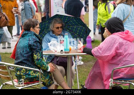 East Molesey, Surrey, Großbritannien. Juli 2021. Es war ein sehr geschäftiger Tag heute am 4. Tag des RHS Hampton Court Palace Garden Festivals. Im echten britischen Stil schien die Sonne am Morgen, aber am Nachmittag folgten heftige Duschen, da Sonnenschirme und Ponchos die Accessoires waren, die man unbedingt haben sollte. Quelle: Maureen McLean/Alamy Stockfoto