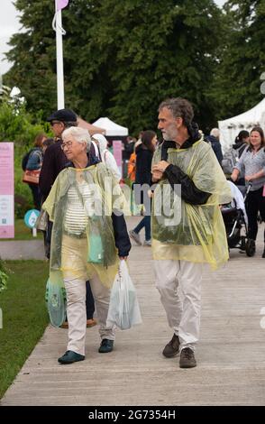 East Molesey, Surrey, Großbritannien. Juli 2021. Es war ein sehr geschäftiger Tag heute am 4. Tag des RHS Hampton Court Palace Garden Festivals. Im echten britischen Stil schien die Sonne am Morgen, aber am Nachmittag folgten heftige Duschen, da Sonnenschirme und Ponchos die Accessoires waren, die man unbedingt haben sollte. Quelle: Maureen McLean/Alamy Stockfoto