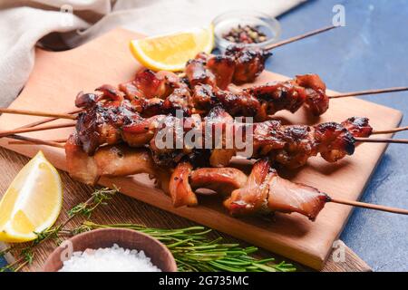 Brett mit leckerem Hähnchen-Kebab auf farbigem Hintergrund Stockfoto