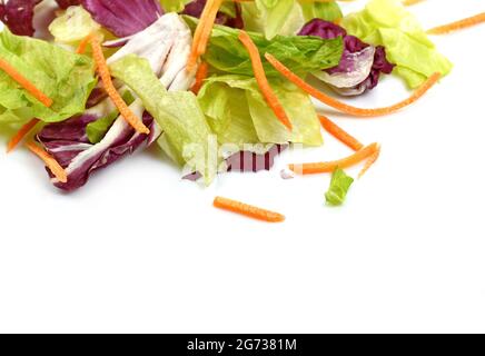 Gemischter Salat isoliert auf weißem Hintergrund. Gemischte Salatblätter, Radicchio, grüner Salat und längs dünn gehackte Karotten. Vitaminbombe. Stockfoto