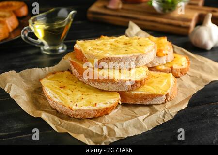 Leckere Toasts mit Käse auf dunklem Holzhintergrund Stockfoto