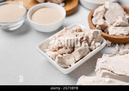 Schüsseln mit frischer Hefe auf hellem Hintergrund Stockfoto