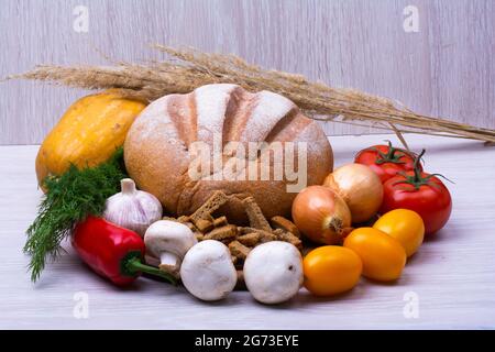Stillleben Nahaufnahme von Gemüse und Brot und Dorn auf weißem Hintergrund Stockfoto