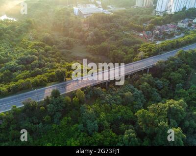 Antennenaufgang Morgen Derevianka Straßenbrücke über Sarzhyn Yar in Kharkiv Stadt. Gebäude mit viel Grün im Nebel bei Morgendämmerung in schönem Licht. Dron Stockfoto