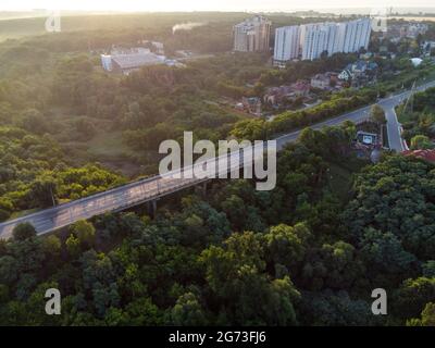 Antennenaufgang Morgen Derevianka Straßenbrücke über Sarzhyn Yar in Kharkiv Stadt. Gebäude mit viel Grün im Nebel bei Morgendämmerung in schönem Licht. Dron Stockfoto