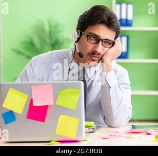 Junge help desk Operator arbeiten im Büro mit vielen widerstreitenden Prioritäten Stockfoto