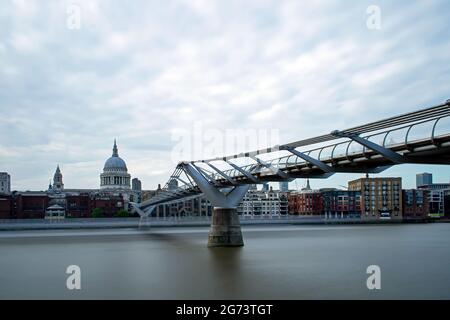 Eine lange Ausstellung der Millennium Bridge und der St Paul's Cathedral, während ein Thames-Klipper von Bankside aus vorbeikommt. London, England. Stockfoto