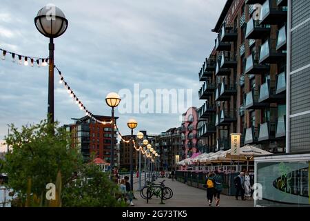 Fußgänger laufen am Flussufer entlang der Shad Thames und Butlers Wharf in London. Die Lagerhäuser werden in Luxuswohnungen und Restaurants umgewandelt. Stockfoto