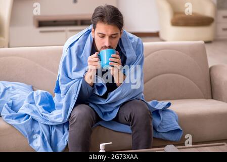 Junger Mann fühlt sich während einer Pandemie zu Hause schlecht Stockfoto