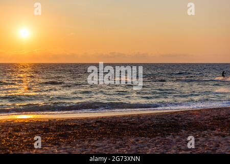Ein wunderschöner Sonnenuntergang über dem Strand von Agios Ioannis in Lefkada, Griechenland Stockfoto