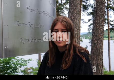 Oslo, Norwegen. Juni 2021. Aestd Willa Eide Hoem, Leiterin der Jugendorganisation der Labour Party (AUF), die es geschafft hat, sich vor dem norwegischen Terroristen anders Behring Breivik unter einem felsigen Aufschluss zu verstecken, steht an einem Denkmal für die 69 Opfer auf der küstennahen Insel. Es ist 10 Jahre her, dass Breivik in Oslo und auf der Insel Utøya insgesamt 77 Menschen getötet hat. Die Polizei hat aus ihren Fehlern gelernt, die soziale Neubewertung beginnt erst jetzt. (To dpa ''Never Again July 22' - Norwegens Antwort auf den Terror') Quelle: Sigrid Harms/dpa/Alamy Live News Stockfoto