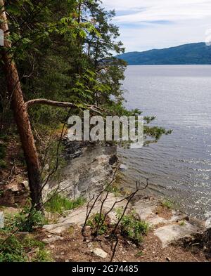 Oslo, Norwegen. Juni 2021. Blick auf einen Felsvorsprung am Ufer, unter dem sich viele junge Menschen vor dem norwegischen Terroristen anders Behring Breivik versteckten. Es ist 10 Jahre her, dass Breivik in Oslo und auf der Insel Utøya insgesamt 77 Menschen getötet hat. Die Polizei hat aus ihren Fehlern gelernt, aber die Gesellschaft beginnt erst jetzt, sich mit der Situation zu vertragen. (To dpa ''Never Again July 22' - Norwegens Antwort auf den Terror') Quelle: Sigrid Harms/dpa/Alamy Live News Stockfoto