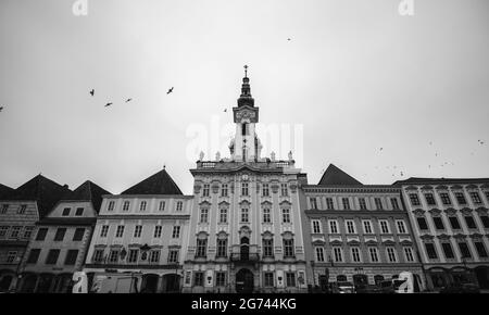 Eine Graustufenaufnahme eines alten Rathauses in Steyr, Österreich, unter einem bewölkten Himmel Stockfoto