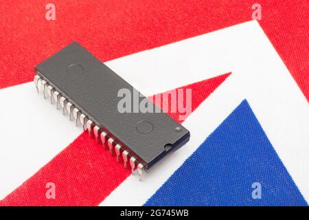 Nahaufnahme des integrierten Schaltkreises/EPROM-Chips auf der kleinen UK Union Jack-Flagge. Bei Halbleitermangel in Großbritannien, Abhängigkeit von britischen Chips, Start-ups von britischen Chips. Stockfoto