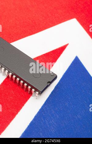 Nahaufnahme des integrierten Schaltkreises/EPROM-Chips auf der kleinen UK Union Jack-Flagge. Bei Halbleitermangel in Großbritannien, Abhängigkeit von britischen Chips, Start-ups von britischen Chips. Stockfoto