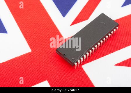 Nahaufnahme des integrierten Schaltkreises/EPROM-Chips auf der kleinen UK Union Jack-Flagge. Bei Halbleitermangel in Großbritannien, Abhängigkeit von britischen Chips, Start-ups von britischen Chips. Stockfoto