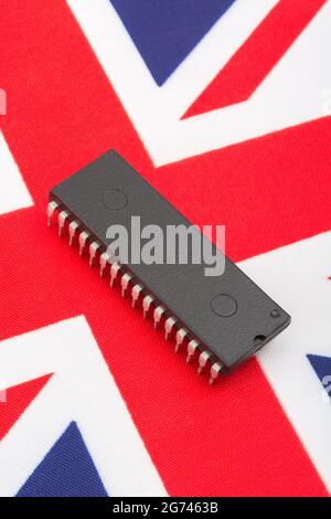 Nahaufnahme des integrierten Schaltkreises/EPROM-Chips auf der kleinen UK Union Jack-Flagge. Bei Halbleitermangel in Großbritannien, Abhängigkeit von britischen Chips, Start-ups von britischen Chips. Stockfoto