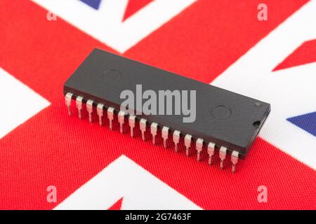 Nahaufnahme des integrierten Schaltkreises/EPROM-Chips auf der kleinen UK Union Jack-Flagge. Bei Halbleitermangel in Großbritannien, Abhängigkeit von britischen Chips, Start-ups von britischen Chips. Stockfoto