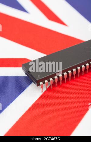 Nahaufnahme des integrierten Schaltkreises/EPROM-Chips auf der kleinen UK Union Jack-Flagge. Bei Halbleitermangel in Großbritannien, Abhängigkeit von britischen Chips, Start-ups von britischen Chips. Stockfoto