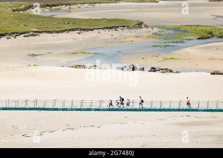 Barleycove, Cork, Irland. Juli 2021. An einem warmen Sommertag überqueren Urlauber eine Fußgängerbrücke über Sanddünen, während sie zum Strand von Barleycove, Co. Cork, Irland, laufen. - Bild; David Creedon / Alamy Live News Stockfoto
