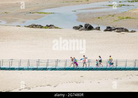 Barleycove, Cork, Irland. Juli 2021. An einem warmen Sommertag überqueren Urlauber eine Fußgängerbrücke über Sanddünen, während sie zum Strand von Barleycove, Co. Cork, Irland, laufen. - Bild; David Creedon / Alamy Live News Stockfoto