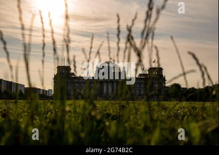 Berlin, Deutschland. Juli 2021. Die Sonne geht hinter dem Reichstagsgebäude auf. Quelle: Christophe Gateau/dpa/Alamy Live News Stockfoto