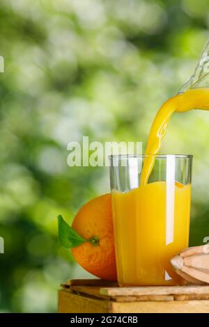 Frischer Orangensaft, der im Freien ins Glas gießt Stockfoto