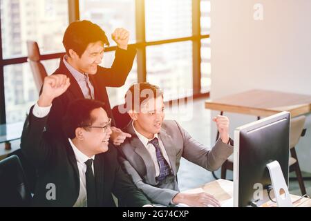 Geschäftsmann gewinnt Erfolg Teamarbeit beobachten gute Nachrichten aus Monitor Computer im Büro, Job fertig beenden und erfolgreiche Team-Konzept. Stockfoto